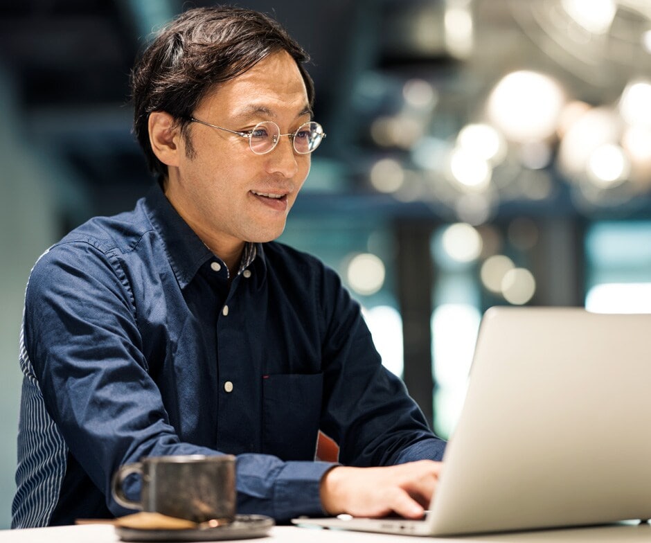 Person mit Brille am Laptop
